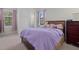 Comfortable bedroom featuring a cozy bed with purple comforter and natural light from the windows at 17045 Polo Trl, Bradenton, FL 34211