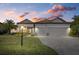 Charming home with a well-manicured lawn, beautiful landscaping, and a three-car garage at sunset at 17045 Polo Trl, Bradenton, FL 34211