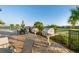 Outdoor grill area with two stainless steel grills, outdoor seating, palm trees, and lake views at 17045 Polo Trl, Bradenton, FL 34211