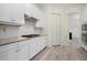 Clean white kitchen featuring granite countertops, a modern range hood, and stainless steel oven at 17045 Polo Trl, Bradenton, FL 34211