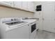 Well-organized laundry room with modern appliances, cabinets, and a sink for added convenience at 17045 Polo Trl, Bradenton, FL 34211