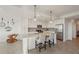 Well-lit kitchen boasts white cabinets, stainless appliances, pendant lights, and a spacious island with barstool seating at 17902 Gawthrop Dr # 302, Lakewood Ranch, FL 34211