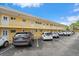 Exterior view of the yellow apartment building with parking and balconies at 2155 Wood St # A20, Sarasota, FL 34237
