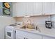 Compact kitchen features clean white cabinets, an oven, and a stainless steel sink at 2155 Wood St # A20, Sarasota, FL 34237