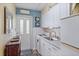 Compact kitchen with white cabinetry, appliances, and blue accent wall, offers a functional cooking space at 2155 Wood St # A20, Sarasota, FL 34237