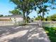 Long driveway leading to a charming home with a white fence and mature trees at 2246 Webber St, Sarasota, FL 34239