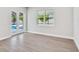 Bright living room with tile floor, white trim, and view to pool from windows and doors at 2319 Webber St, Sarasota, FL 34239