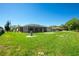 Expansive backyard view showcasing lush green grass and a spacious screened-in lanai at 25422 Aysen Dr, Punta Gorda, FL 33983