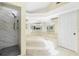 Bright bathroom featuring a large bathtub, tiled floors, and separate shower with marble-style tile at 25422 Aysen Dr, Punta Gorda, FL 33983