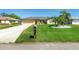 Landscaped single-story home with green grass and a gray roof, adding to its curb appeal at 25422 Aysen Dr, Punta Gorda, FL 33983