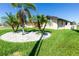 Landscaped front yard with decorative stone and palm trees enhances curb appeal at 25422 Aysen Dr, Punta Gorda, FL 33983