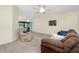 Spacious living room featuring carpeted floors, a ceiling fan, and a sliding glass door at 25422 Aysen Dr, Punta Gorda, FL 33983