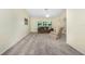 Inviting living room with plush carpeting, comfortable seating, and natural light from large windows at 25422 Aysen Dr, Punta Gorda, FL 33983