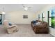 Bright living room boasts carpeted floors, windows, and a contemporary ceiling fan at 25422 Aysen Dr, Punta Gorda, FL 33983