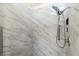 Close up of the modern shower featuring a rainfall shower head and marble-style tile at 25422 Aysen Dr, Punta Gorda, FL 33983