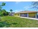 View of the home's backyard featuring a well-maintained lawn and a screened in patio at 27142 Villarrica Dr, Punta Gorda, FL 33983