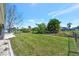 Large fenced-in backyard with mature trees, well-maintained lawn, and abundant space for outdoor enjoyment at 27142 Villarrica Dr, Punta Gorda, FL 33983