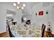 Bright dining area with white walls, chandelier, and lemon-themed tablecloth near kitchen and living area at 27142 Villarrica Dr, Punta Gorda, FL 33983