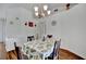 Bright dining area with white walls, chandelier, and lemon-themed tablecloth in neutral palette at 27142 Villarrica Dr, Punta Gorda, FL 33983