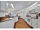 Bright kitchen featuring white cabinets, granite countertops, and wood-look flooring with access to dining area at 27142 Villarrica Dr, Punta Gorda, FL 33983