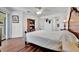 Spacious main bedroom featuring wood floors, ceiling fan, dresser, and an attached bathroom at 27142 Villarrica Dr, Punta Gorda, FL 33983