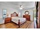 Well-lit main bedroom with wood floors, ceiling fan, and sliding glass door to a screened-in patio at 27142 Villarrica Dr, Punta Gorda, FL 33983