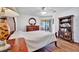 View of the main bedroom featuring wood floors, ceiling fan, and dresser with matching bedside tables at 27142 Villarrica Dr, Punta Gorda, FL 33983