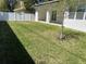Lush backyard featuring a well-maintained lawn, white fence, and covered patio, perfect for outdoor enjoyment at 3204 W Grace St, Tampa, FL 33607