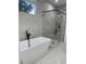 Bathroom boasting a soaking tub, walk-in glass shower with white marble look tiles and black fixtures at 3204 W Grace St, Tampa, FL 33607
