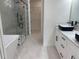 Modern bathroom featuring double vanities, elegant tile flooring, and a glass-enclosed shower at 3204 W Grace St, Tampa, FL 33607