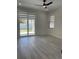 Bright bedroom boasts wood-look flooring, neutral paint, ceiling fan, sliding glass doors to patio at 3204 W Grace St, Tampa, FL 33607