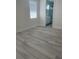 Clean bedroom with wood-look flooring and a window, leading into a bathroom at 3204 W Grace St, Tampa, FL 33607