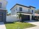 Contemporary home showcasing modern design with a dark garage door, stone accents, and well-kept lawn at 3204 W Grace St, Tampa, FL 33607
