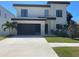 Modern two-story home boasts a dark garage door, manicured lawn, and stone accents for curb appeal at 3204 W Grace St, Tampa, FL 33607