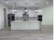 Bright kitchen features white cabinets, a spacious island, stainless appliances, and elegant pendant lights at 3204 W Grace St, Tampa, FL 33607