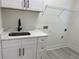 Bright laundry room with a white cabinet sink and stylish fixtures at 3204 W Grace St, Tampa, FL 33607
