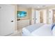 Bedroom with modern dresser with TV, and access to ensuite bathroom and walk-in closet at 322 Beach Rd, Sarasota, FL 34242