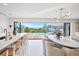 Contemporary kitchen and dining area with island seating and sliding doors to an outdoor pool deck at 322 Beach Rd, Sarasota, FL 34242