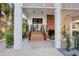 Inviting front entrance features a wooden staircase, black railings, and lush landscaping, creating a warm and welcoming ambiance at 322 Beach Rd, Sarasota, FL 34242