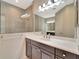 Modern bathroom with dark cabinets, white countertop, large mirror and glass enclosed shower at 324 Casalino Dr, Nokomis, FL 34275