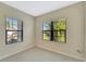 Well-lit bedroom with tile floors and ample natural light from two windows at 324 Casalino Dr, Nokomis, FL 34275