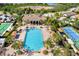 Aerial view of the community pool, tennis and bocce ball courts, with views of surrounding homes and lake at 324 Casalino Dr, Nokomis, FL 34275