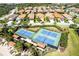 Aerial view of the community tennis courts near the pool and other neighborhood homes at 324 Casalino Dr, Nokomis, FL 34275