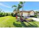 Charming home with a tile roof, manicured lawn, and beautiful landscaping with palm trees and red bromeliads at 324 Casalino Dr, Nokomis, FL 34275