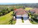 Charming home featuring a three-car garage, lush landscaping, and a welcoming paved driveway at 324 Casalino Dr, Nokomis, FL 34275