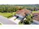 A well-manicured home with a three-car garage, lush landscaping, and a paved driveway at 324 Casalino Dr, Nokomis, FL 34275