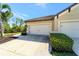 Attached two-car garage with a concrete driveway and manicured landscaping adding to the curb appeal at 324 Casalino Dr, Nokomis, FL 34275