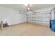 Spacious two-car garage with a tan floor, white walls, and an insulated sectional door at 324 Casalino Dr, Nokomis, FL 34275