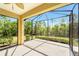 A screened-in lanai with a concrete floor offers outdoor living and views of lush landscaping at 324 Casalino Dr, Nokomis, FL 34275