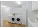 Spacious laundry room featuring washer, dryer, plentiful cabinets and counter space, and a refrigerator at 35 Watergate Dr # 1402, Sarasota, FL 34236
